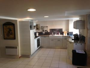 a large kitchen with white cabinets and a sink at Eymet Townhouse in Eymet