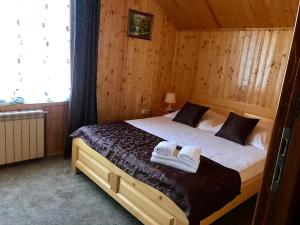 a bedroom with a bed with two towels on it at Pensiunea Silva Dobra in Şugag