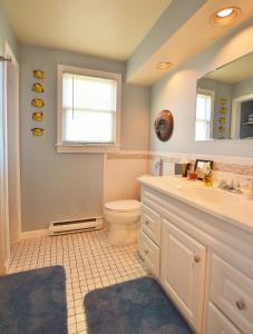 ein Badezimmer mit einem WC, einem Waschbecken und einem Spiegel in der Unterkunft The John Randall House in Provincetown