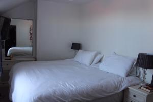 a bed with white sheets and pillows in a bedroom at Walmer House in Deal