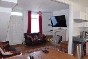 a living room with a couch and a tv at Walmer House in Deal