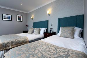 ダンフリーズにあるThe Farmers Innのベッド2台と枕2つが備わるホテルルームです。