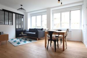 uma sala de estar com uma mesa e um sofá em 3 Pièces à 50 mètres du bord de mer em Saint Malo