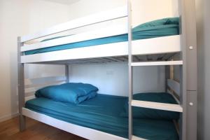 a bunk bed room with two bunk beds with blue pillows at 3 Pièces à 50 mètres du bord de mer in Saint Malo