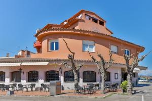 a building with tables and chairs in front of it at Hostal Alberana in Verges