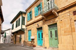 a building with blue and green doors on a street at Bougainvillea Garden in Lefkosa Turk