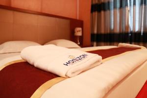Postel nebo postele na pokoji v ubytování Horizon Hotel Apartments - الأفق للشقق الفندقية