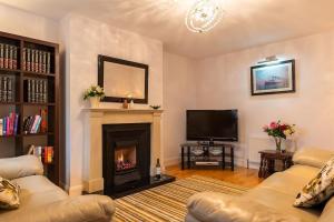 a living room with a fireplace and a tv at Salmons Leap Sneem Village Kerry in Sneem