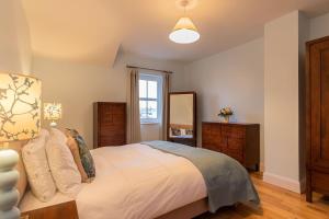 Un dormitorio con una gran cama blanca y una ventana en Salmons Leap Sneem Village Kerry en Sneem