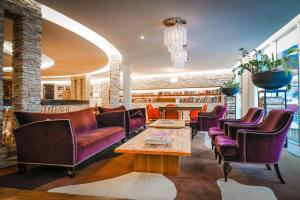 hol z kanapami, stołem i krzesłami w obiekcie Hotel Alpine Palace w Saalbach Hinterglemm