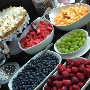 una mesa cubierta con tazones de fruta y postres en Residencial del Maule, en Linares