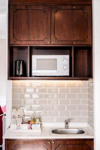 a kitchen with a sink and a microwave at Maison De Camille Boutique Hotel in Ho Chi Minh City