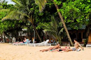 a group of people laying on the beach at Sea Star Resort in Phú Quốc