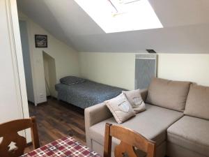 a living room with a couch and a bed at Les cottages de Magny in Magny-les-Hameaux