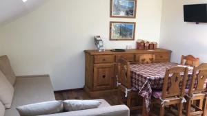 a living room with a table and a couch at Les cottages de Magny in Magny-les-Hameaux