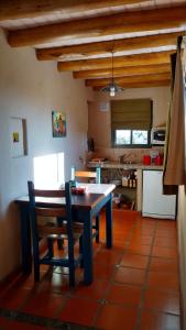a kitchen with a table and chairs in a room at Cabañas Chacras del Arroyo Vidal in Carpintería