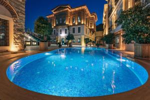 a large blue swimming pool in a courtyard at night at Seven Hills Palace & Spa in Istanbul