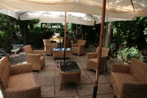 eine Gruppe Stühle und ein Sonnenschirm auf einer Terrasse in der Unterkunft Hotel Ristorante Solari in Briatico