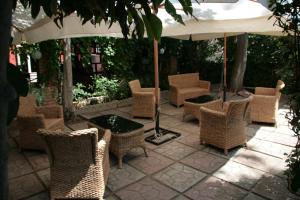 eine Gruppe von Stühlen, Tischen und einem Schirm in der Unterkunft Hotel Ristorante Solari in Briatico