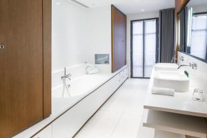 a bathroom with two sinks and a bathtub and a tub and sink at Hotel C2 in Marseille