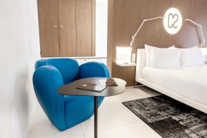 a room with a blue chair and a bed at Hotel C2 in Marseille