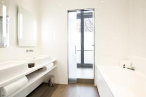 a white bathroom with two sinks and a shower at Hotel C2 in Marseille