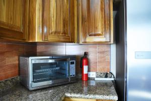 a kitchen counter with a microwave and a fire extinguisher at Lucina's in San Ignacio +10 photos