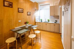 a kitchen with a table and stools in a room at Alfa Apartments Svobody 31 in Lviv