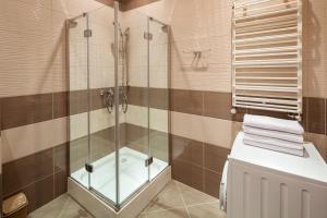 a bathroom with a glass shower and a toilet at Alfa Apartments Svobody 31 in Lviv