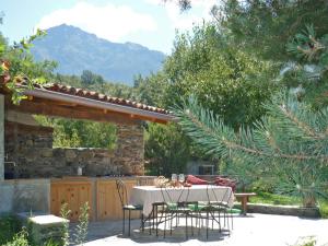 un patio con mesa y sillas y un edificio de piedra en Villa Erica con piscina privata sul lago di Como, en Colico