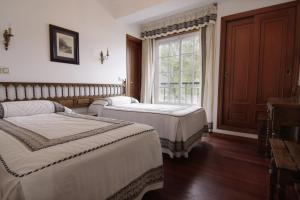 a bedroom with two beds and a window at As Areas I in Viveiro