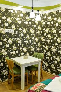 クタイシにあるHOSTEL LOOKの花の壁紙を用いたダイニングルームテーブルと椅子