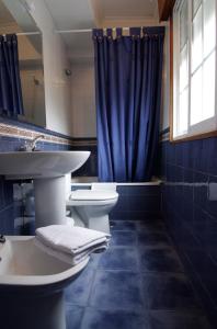 baño con 2 lavabos y cortina de ducha azul en As Areas I, en Viveiro