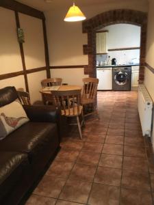a living room with a couch and a table at Domvilles Farm self catering Courtyard Stable in Alsager