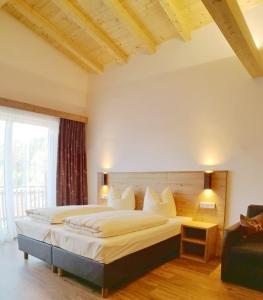 a bedroom with a large bed and a couch at Hotel Jagdhof in Kramsach