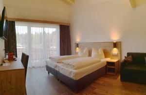 a bedroom with a large bed and a balcony at Hotel Jagdhof in Kramsach