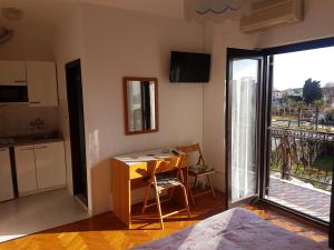 a room with a desk and a kitchen with a balcony at Apartments Zova in Medulin