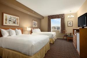 Säng eller sängar i ett rum på Days Inn & Suites by Wyndham West Edmonton