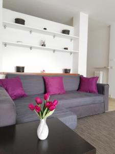 a living room with a couch and a vase with pink flowers at Boschetto in Riva del Garda