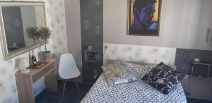 Dormitorio pequeño con cama y espejo en Patrick&Pierre Bed and Breakfast Nîmes en Nimes
