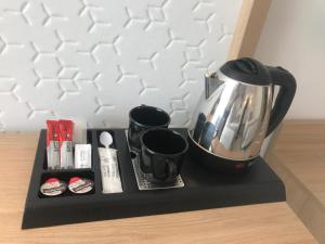 a tea kettle on a black tray on a table at Hotel Madeira Centro in Benidorm