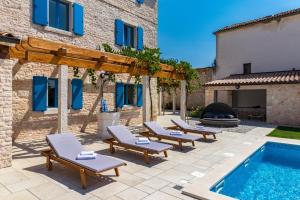 een patio met ligstoelen en een zwembad bij Villa Racan in Bokordići