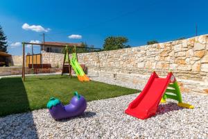 een speeltuin met twee glijbanen en een schommel bij Villa Racan in Bokordići