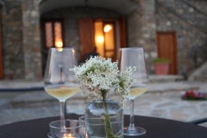 dos copas de vino y un jarrón de flores en una mesa en Casa Amigdala en Castellabate