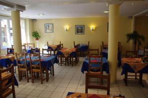 jadalnia z niebieskimi stołami i krzesłami w obiekcie Hotel de Bordeaux w mieście Gramat