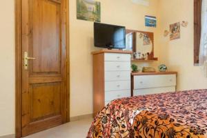 um quarto com uma cama e uma cómoda com uma televisão em Kate em Gavorrano