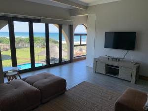 a living room with a flat screen tv and a couch at 61 Cabanas in Durban