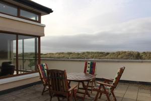 uma mesa e cadeiras numa varanda com vista em The Beach House em Enniscrone