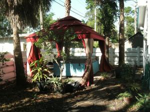 um gazebo vermelho num quintal com plantas em Newly Furnished Large Clean Quiet Private Unit em Fort Lauderdale