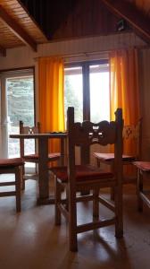 mesa y sillas en una habitación con ventana en Anthar Andes en Potrerillos